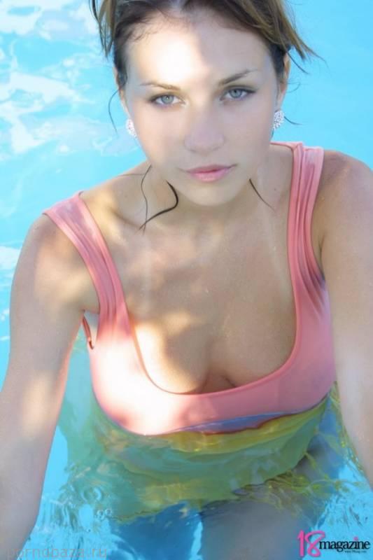 Молодая девушка с красивыми формами купается в бассейне